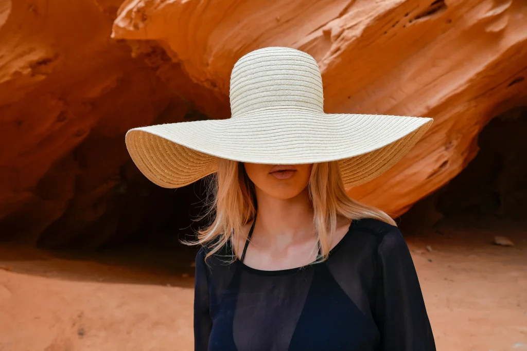 Frau mit XL-Strohhut zeigt den Hut Trend Sommer 2026