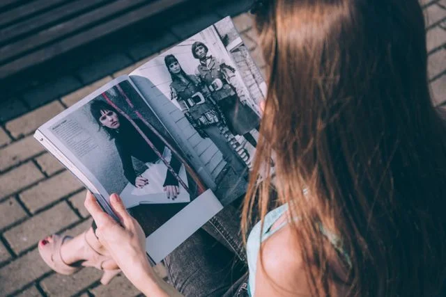 Frau betrachtet ein aufgeschlagenes Modemagazin
