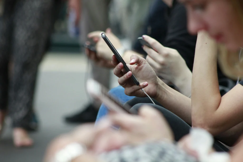 Person blickt auf ihr Smartphone und scrollt durch eine Shopping-App als Symbol für die Second-Hand-Spirale und Vinted-Müdigkeit.