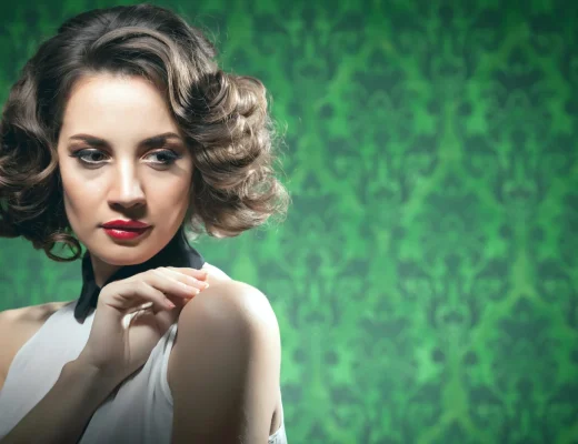 Frau mit voluminösem Retro-Bob und elegant geformten Wellen vor grünem Hintergrund