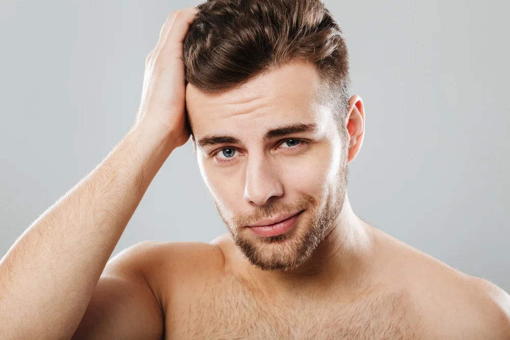 Mann mit gestylten Haaren fährt sich mit der Hand durch die Haare