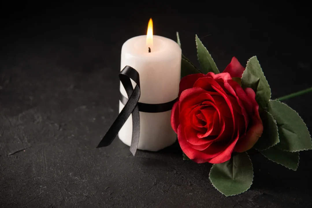 Trauerkerze mit schwarzer Schleife und roter Rose zum Tod von Presley Gerber