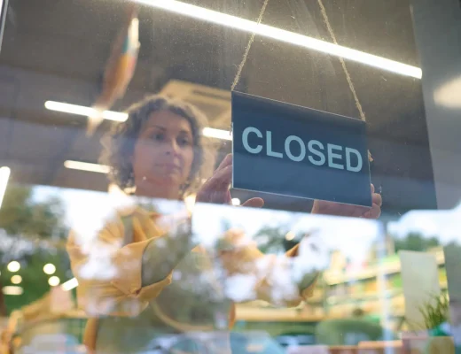 Symbolbild einer Mitarbeiterin, die ein Closed-Schild ins Schaufenster hängt – Galeria-Insolvenz 2026