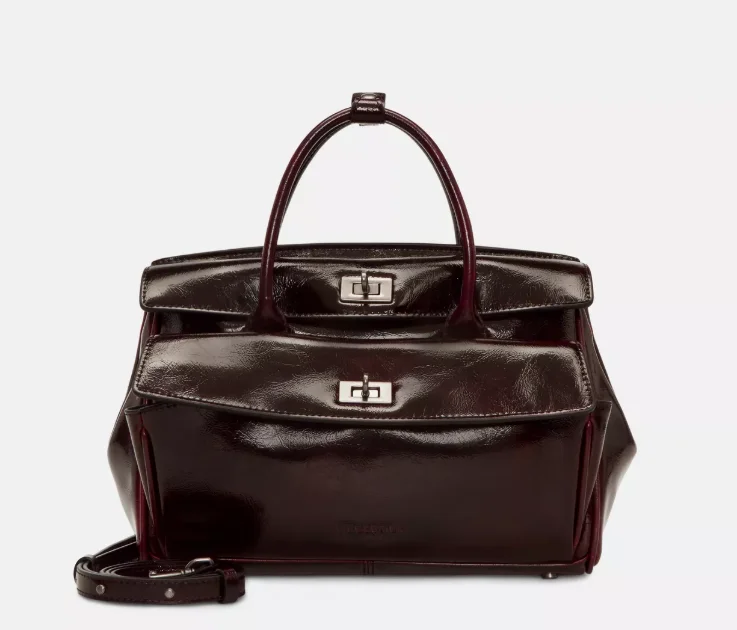 Liebeskind Archive Gloria II Satchel M in glänzendem Bordeaux mit zwei Drehverschlüssen, kurzen Henkeln und zusätzlicher Fronttasche.