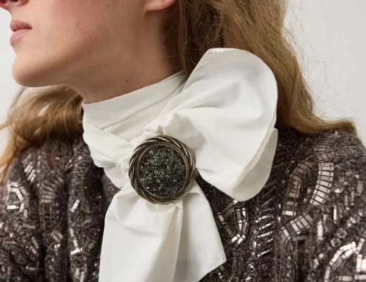 Große Brosche als Verschluss an einem weißen Schal zu einem eleganten Herbst-Look