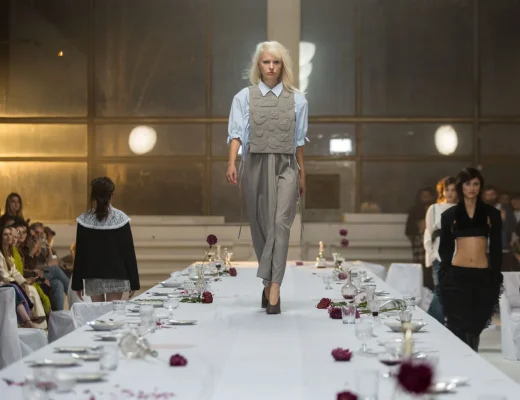 Model mit grauem Outfit auf einem langen, weiß gedeckten Laufsteg bei der Moldovan Brands Runway 2026 in Chișinău.
