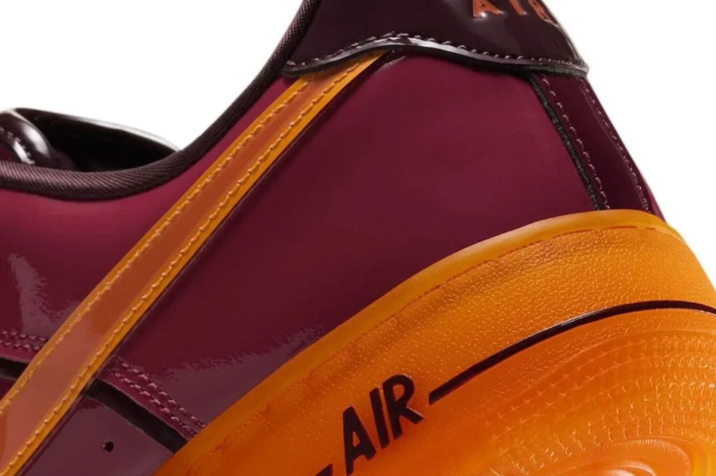 Detailaufnahme des Nike Air Force 1 Iron Man mit orangefarbenem Swoosh und leuchtender Außensohle
