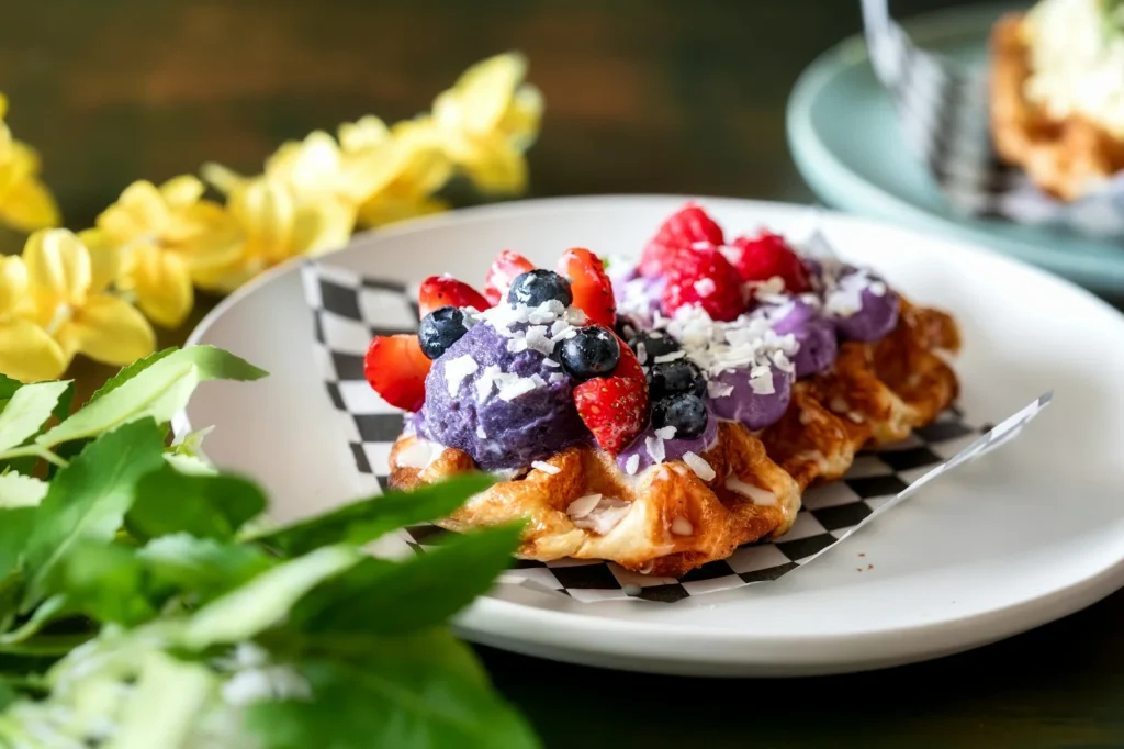 Croissant mit violetter Creme, frischen Beeren und Kokosraspeln als Symbolbild für den Ube-Food-Trend