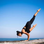Frau in Lululemon Leggings beim Yoga-Handstand am Strand – Athleisure Outfit für Training und Alltag