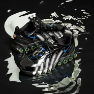 Paar des Patta x Nike Air Max DN8 auf schwarzer, spiegelnder Oberfläche mit Metallic-Panels und grünen Air-Kapseln.