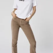 Cordhose Damen Herbstrend: schlanke Flared-Cordhose in Karamellbraun, weißes T-Shirt, schwarze Loafer – cleaner Herbstlook im Studio