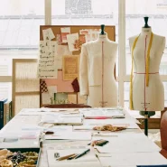 Atelier-Szene mit Schneiderpuppen, Stoffmustern und Entwurfsunterlagen im Stil von Sézane Quelle: sezane.com – Über uns