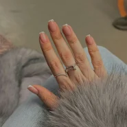 Gepflegte Fingernägel mit natürlicher French-Maniküre und glänzender Oberfläche als Beispiel für sorgfältige Nagelpflege.